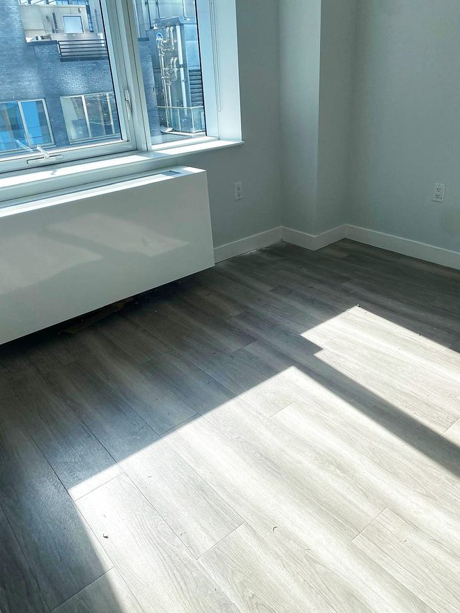 Sunlight falling across a clean plank floor by a window