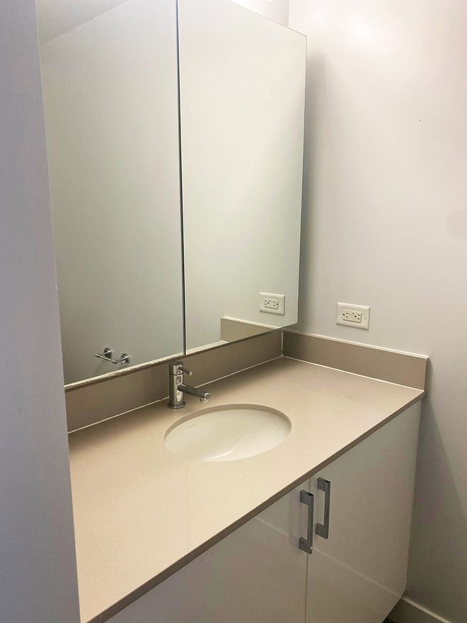 A bathroom mirror and counter, cleaned and streak-free
