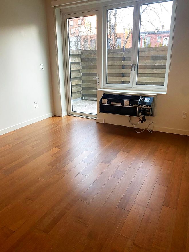 A clean hardwood floor beside a patio door with daylight coming in
